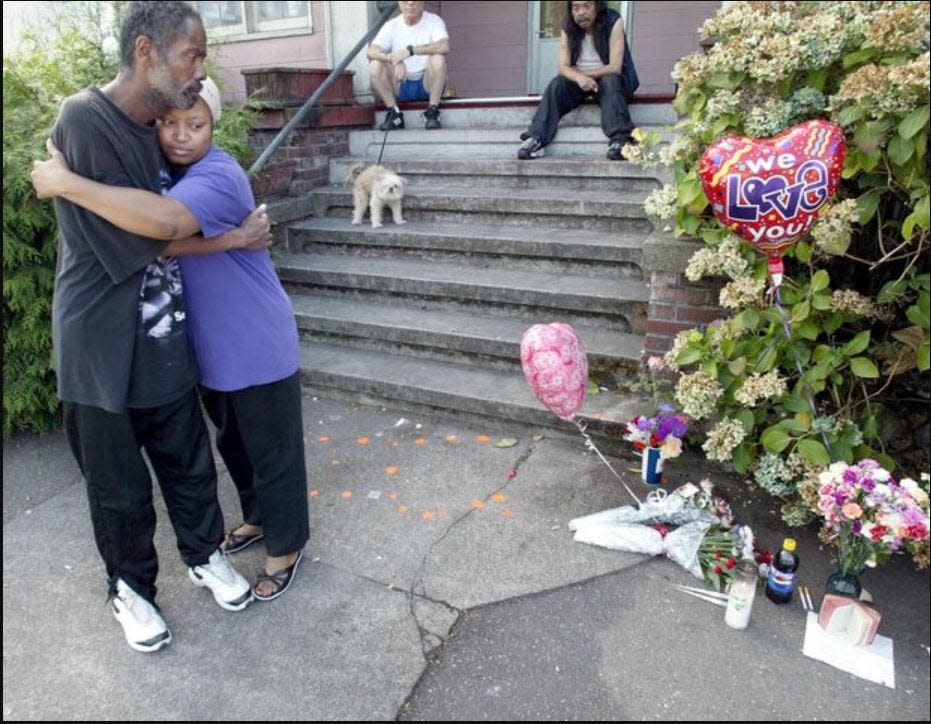 In the aftermath of Janet Eaton's murder in 2005, Tony Ragsdale hugs Nina Stokes next to a memorial for Eaton on the steps of this house on Sixth Street in Bremerton.