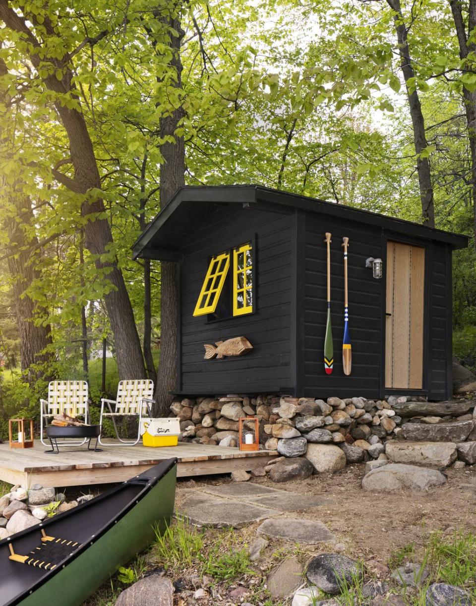 black boathouse with bright yellow window trim