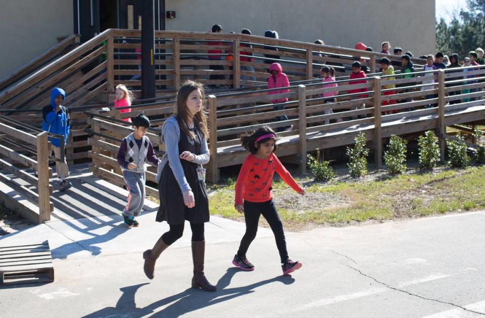 Students, led by first grade teacher Kimberley Maret, exit their modular classroom unit as they head to physical education class at Cedar Fork Elementary School in Morrisville in this 2016 file photo.