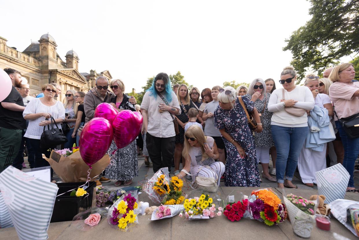 Members of the public take part in a vigil near to the scene in Hart Street, Southport, where three children died and eight were injured in a 