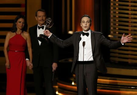 Jim Parsons accepts the award for Outstanding Lead Actor In A Comedy Series for his role in "The Big Bang Theory" as presenters Julia-Louis Dreyfus and Bryan Cranston look on during the 66th Primetime Emmy Awards in Los Angeles, California August 25, 2014. REUTERS/Mario Anzuoni