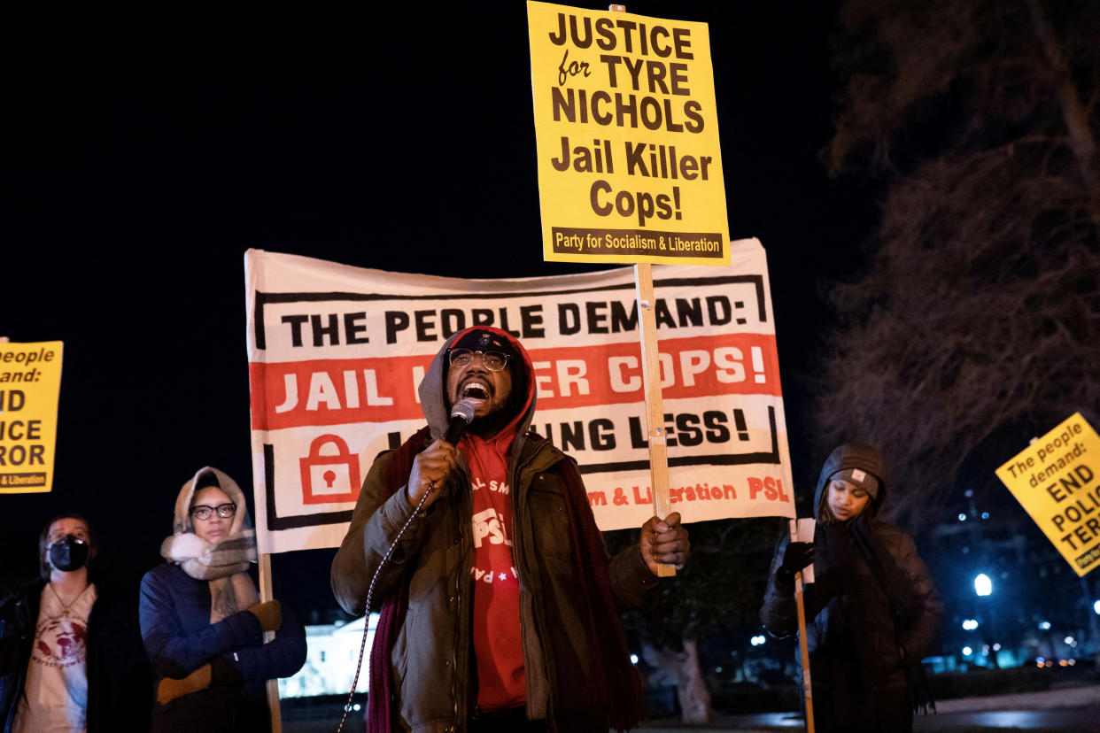 Sean Blackmon leads a chant as protesters gather near the White House, with a Party for Socialism and Liberation sign behind him saying: The People Demand, Jail Killer Cops!