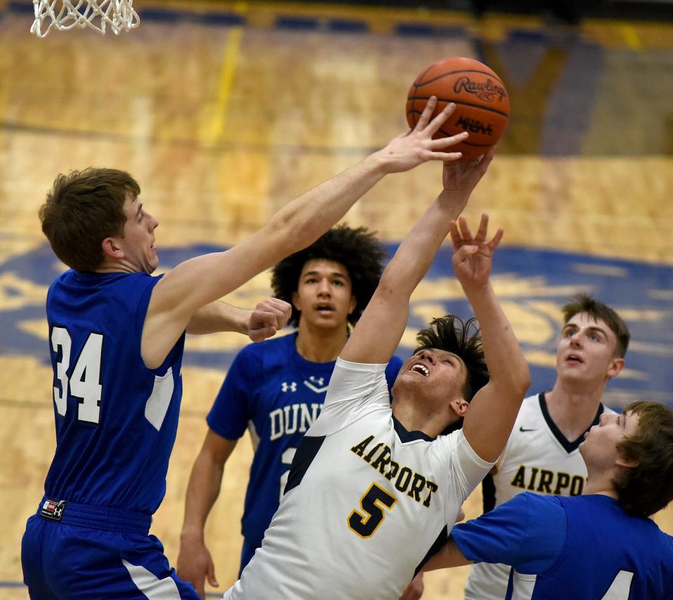 Adam Spare of Dundee blocks the shot of Brandon McCormas of Airport in the Division 2 District semifinals at Dundee High School Thursday.