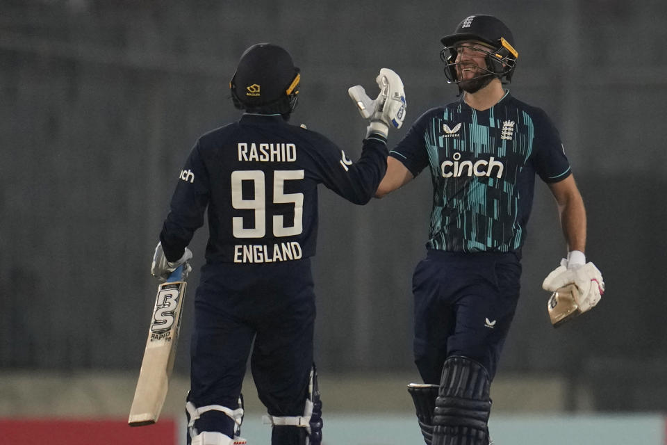 England's Dawid Malan, right, and Adil Rashid celebrate after their win in the first one day international cricket match between Bangladesh and England in Dhaka, Bangladesh, Wednesday, March 1, 2023. (AP Photo/Aijaz Rahi)