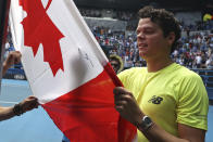 Canada's Milos Raonic signs his autograph onto a Canadian flag after defeating Croatia's Marin Cilic in their fourth round singles match at the Australian Open tennis championship in Melbourne, Australia, Sunday, Jan. 26, 2020. (AP Photo/Dita Alangkara)
