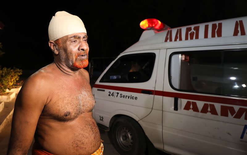 An injured civilian stands outside Madina Hospital after a blast at the Luul Yemeni restaurant near the port in Mogadishu