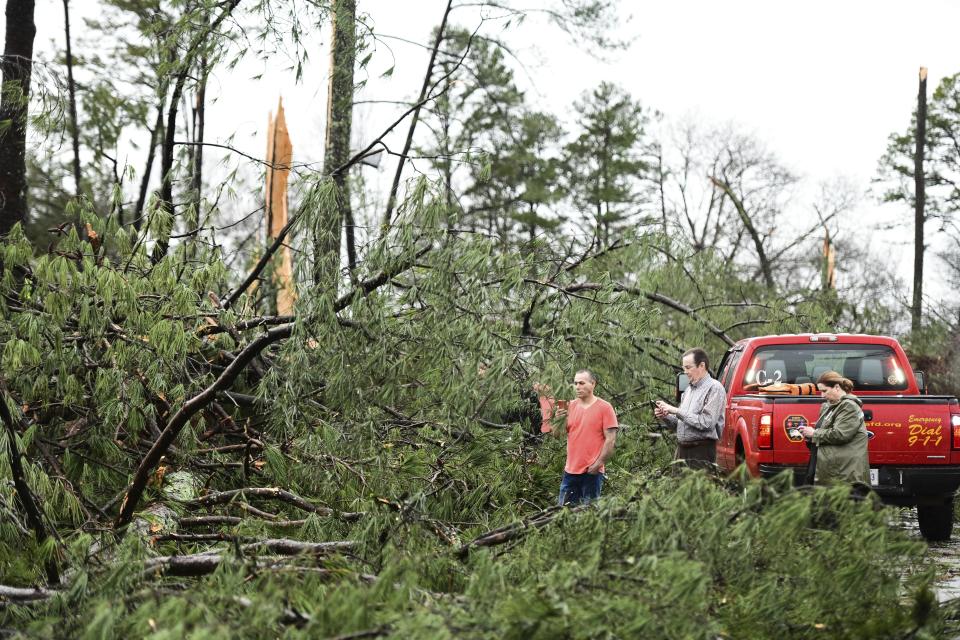 CORRECTS YEAR TO 2020 NOT 2019 - People stand among downed trees at an apartment complex damaged by a reported tornado Thursday, Feb. 6, 2020, in Spartanburg, S.C. A powerful winter storm brought severe weather across the Deep South early Thursday, with high winds causing damage that killed one person, injured several others and littered at least four states. (AP Photo/Sean Rayford)