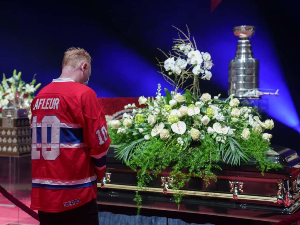 A hockey fan pays his respects to former Montreal Canadiens player Guy Lafleur during a visitation at the Bell Centre in Montreal on Sunday. (Paul Chiasson/The Canadian Press - image credit)