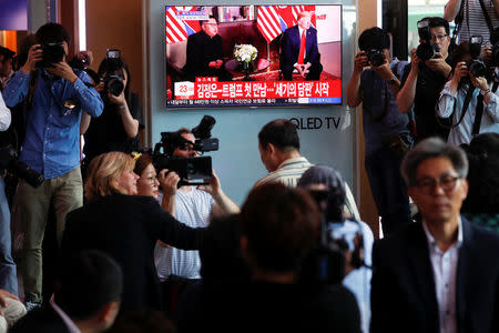 People watch a TV broadcasting a news report on summit between the U.S. and North Korea, in Seoul, South Korea, June 12, 2018. REUTERS/Kim Hong-Ji