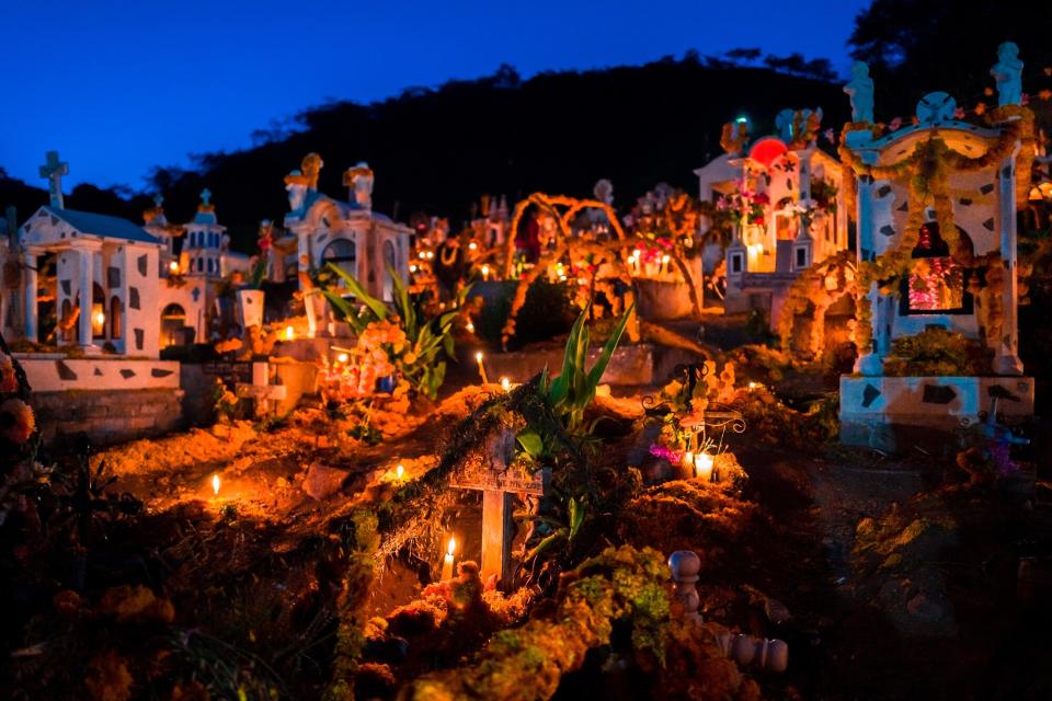 Tombs and graves, decorated with marigold flowers, are seen illuminated by burning candles during the Day of the Dead celebrations at the cemetery on November 2, 2021 in Xalpatláhuac, Mexico. Day of the Dead (Día de Muertos), a religious holiday combining the death veneration rituals of Pre-Hispanic cultures with the Catholic practice, is widely celebrated throughout all of Mexico. Based on the belief that the souls of the departed may come back to this world on that day, people gather to pray, eat, drink or play music, to remember friends or family members who have died and to support their souls on the spiritual journey.