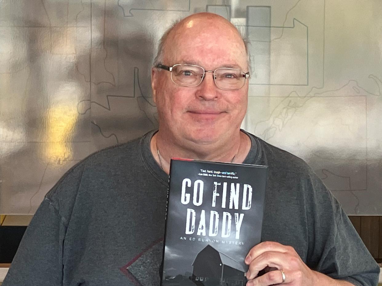 Steve Goble poses with a copy of his book, "Go and find daddy," which was nominated for a Shamus Award by the Private Eye Writers of America.