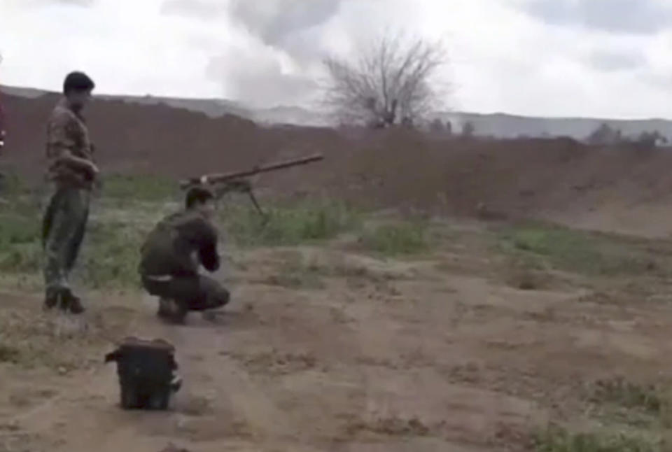 This frame grab from video provided on Tuesday, Feb. 12, 2019, by the Syrian Observatory for Human Rights, an opposition group, that is consistent with independent AP reporting, shows U.S.-backed Syrian Democratic Forces fighters take their position during a battle against Islamic State group militants, in the village of Baghouz, Deir El-Zour, eastern Syria. Fighting between U.S.-backed fighters and IS inflicted more casualties among people fleeing the violence in eastern Syria Tuesday where the extremists are on the verge of losing the last area they control. (Syrian Observatory for Human Rights via AP)