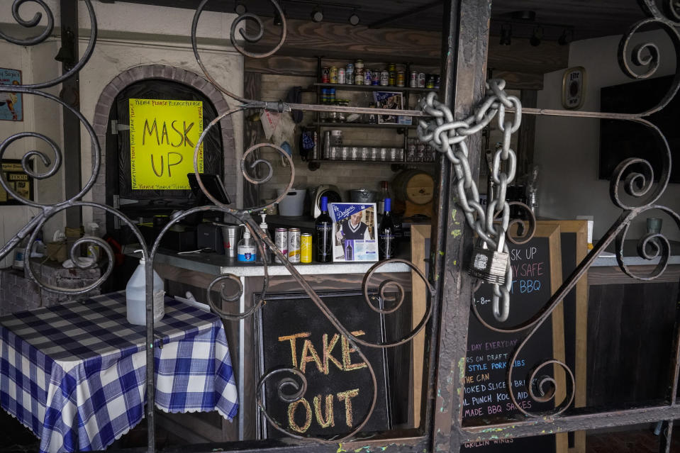 The doors of the Baby Blues BBQ restaurant are seen locked in Los Angeles Monday, Jan. 25, 2021. California has lifted regional stay-at-home orders statewide in response to improving coronavirus conditions. Public health officials said Monday that the state will return to a system of county-by-county restrictions intended to stem the spread of the virus. Local officials could choose to continue stricter rules. The state is also lifting a 10 p.m. to 5 a.m. curfew. (AP Photo/Damian Dovarganes)