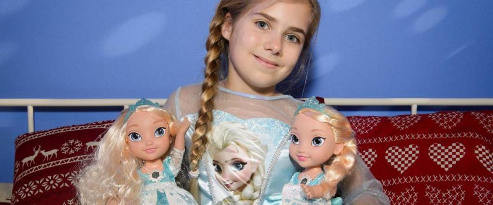 Girl holds Elsa dolls