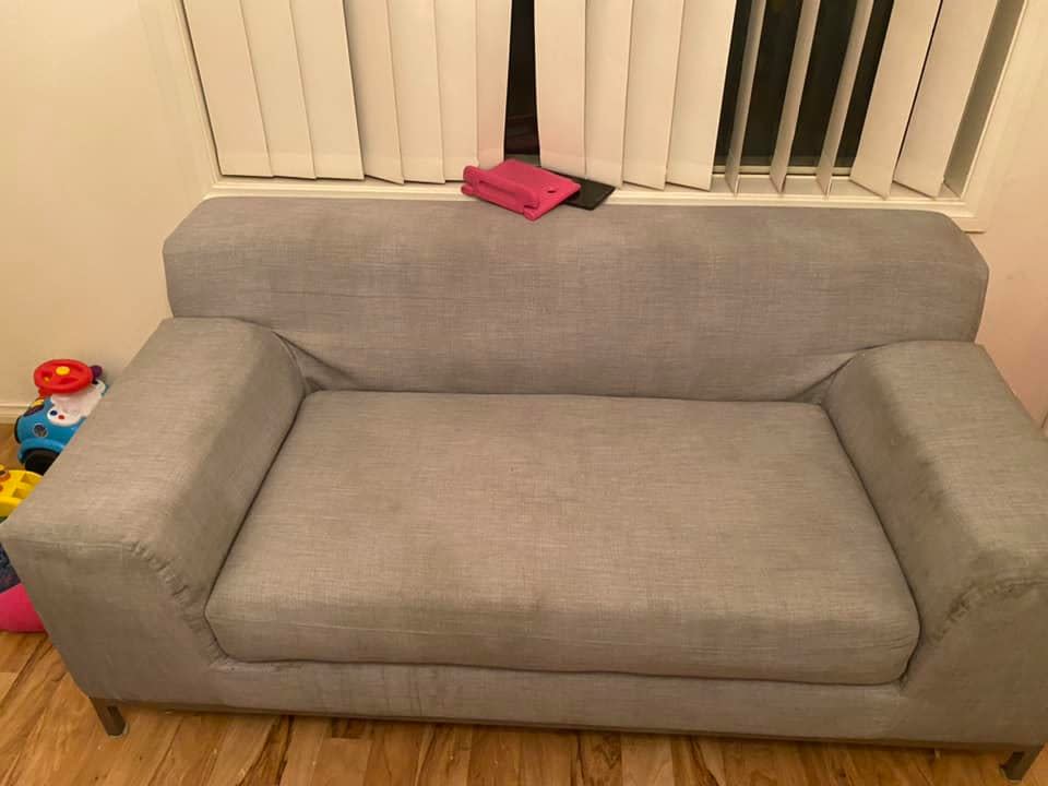 A grey couch inside a children's playroom