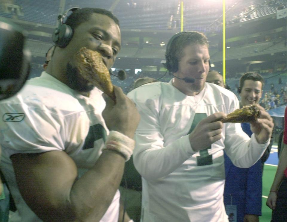 Green Bay Packers players Ahman Green and Brett Favre feast on turkey legs after the Thanksgiving Day game against the Detroit Lions on Nov. 22, 2001. Traditionally, the winners feast on turkey after the game for a national television audience. Ernie Mastroianni photo