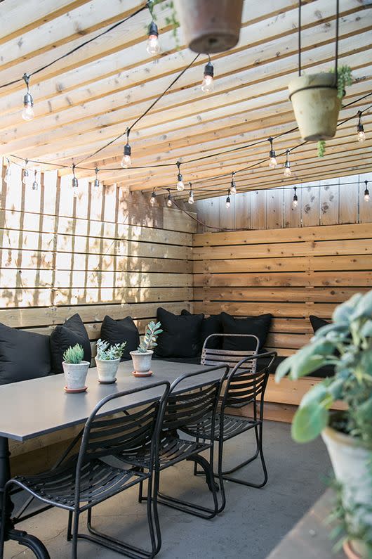 outdoor dining nook with bench seating and a table under a shaded pergola