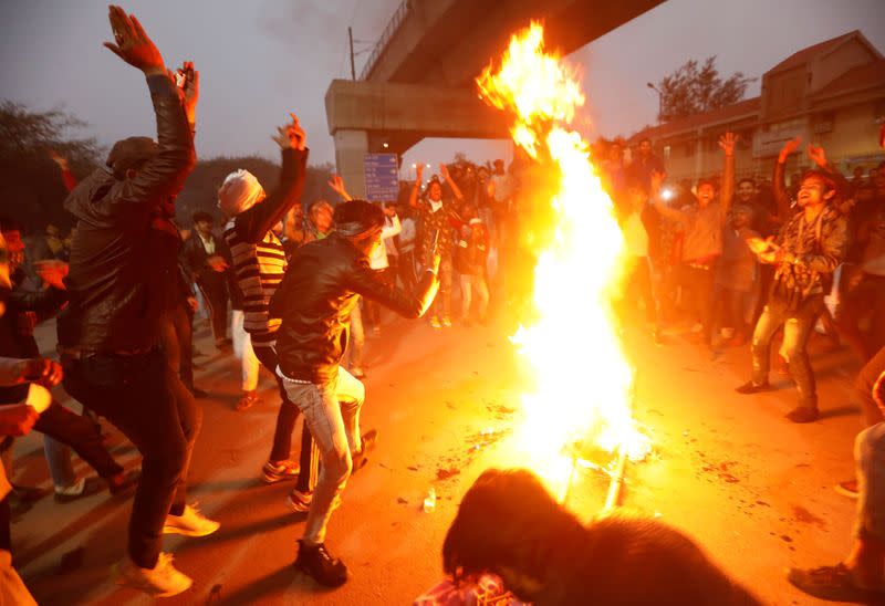 Demonstrators burn an effigy depicting PM Modi during a protest against a new citizenship law, in New Delhi