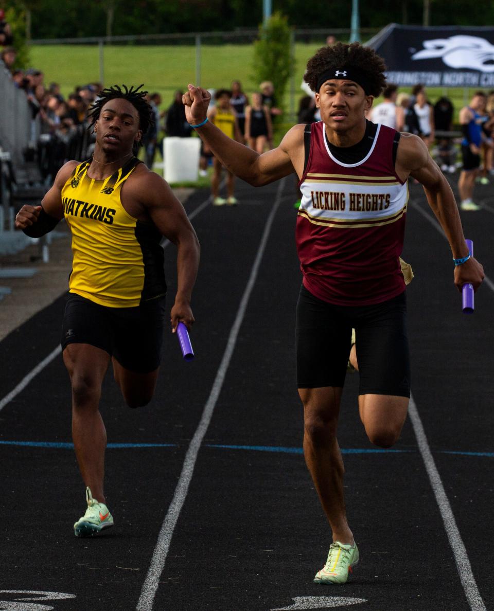 Watkins Memorial senior Jaleel Sales and Licking Heights junior D.J. Fillmore lean at the line in the 400 relay during the Division I regional championships at Pickerington North on Friday, May 27, 2022. Watkins and Heights each broke its school record.
