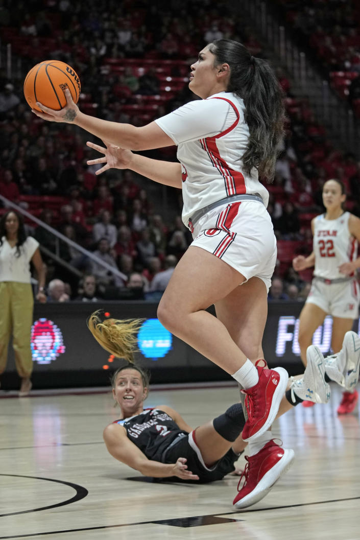 Utah forward Alissa Pili (35) drives as Gardner-Webb guard Lauren Bevis (2) falls while defending during the first half of a first-round college basketball game in the women's NCAA Tournament, Friday, March 17, 2023, in Salt Lake City. (AP Photo/Rick Bowmer)
