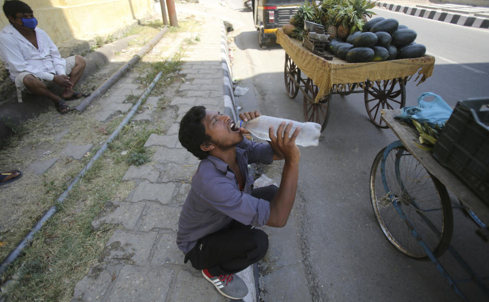 A vendor drinks water on a summer day in Jammu, India, Tuesday, May 26, 2020. Many northern cities in India are reeling under an intense heat wave with the temperatures on Wednesday crossing a scorching 45 degrees Celsius (113 degrees Fahrenheit). (AP Photo/Channi Anand)