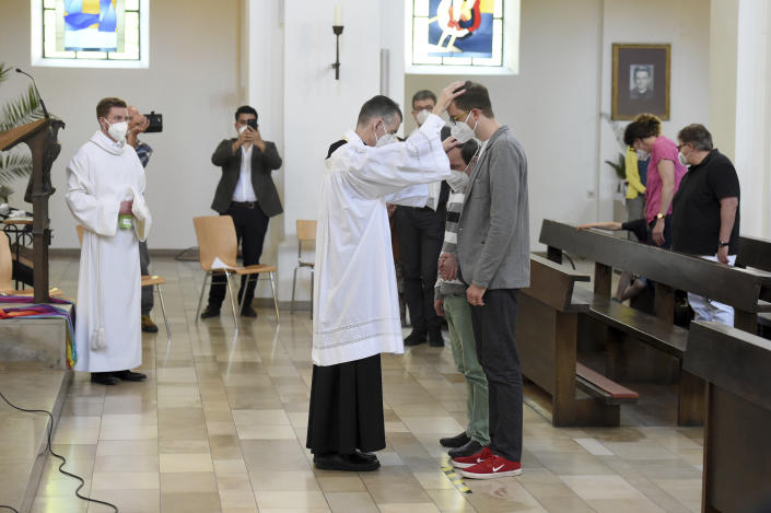 FILE - Vicar Wolfgang Rothe, center, blesses two men during a Catholic service with the blessing of same-sex couples in St Benedict's Church in Munich, Sunday, May 9, 2021. Pope Francis said in an interview with The Associated Press at The Vatican on Tuesday, Jan. 24, 2023, that there's a risk that what could be a trailblazing reform process in the German church could become "ideological." (Felix Hoerhager/dpa via AP, file)