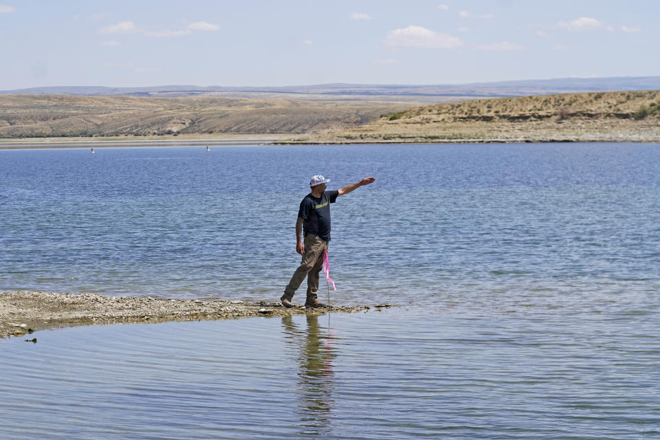 Tony Valdez, owner of Buckboard Marina, walks along the receding edge of his marina Thursday, Aug. 4, 2022, on the northwestern side of Flaming Gorge Reservoir in Wyoming. A boating and fishing paradise on the Utah-Wyoming line, Flaming Gorge is beginning to feel the effects of the two-decade megadrought gripping the southwestern U.S. (AP Photo/Rick Bowmer)