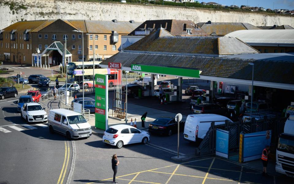 A man looks on as drivers queue to enter a supermarket petrol station as concern spreads over fuel supplies in Brighton, England - Leon Neal /Getty Images Europe 