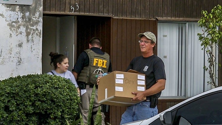 Federal agents remove evidence from an office at the Green Terrace condominium, where the condos have been converted to a sober living home, on Sept. 11, 2014, in West Palm Beach. Green Terrace is off of Belvedere Road east of Interstate 95. (Greg Lovett / The Palm Beach Post)