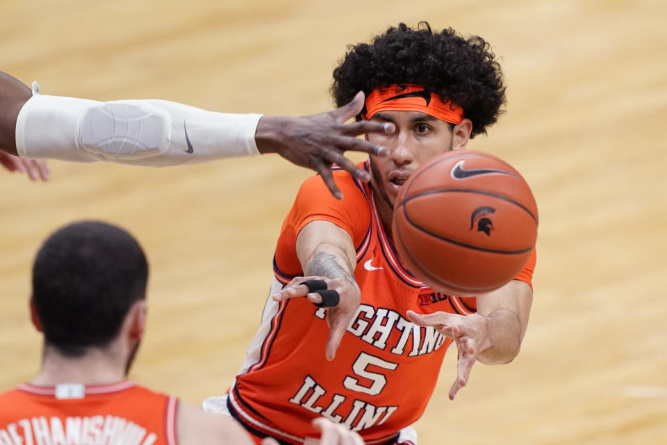 Illinois guard Andre Curbelo (5) passes to forward Giorgi Bezhanishvili during the first half of an NCAA college basketball game against Michigan State, Tuesday, Feb. 23, 2021, in East Lansing, Mich. (AP Photo/Carlos Osorio)