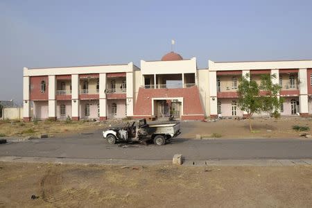 A burnt pickup truck is seen in front of a building that Boko Haram insurgents used as their base before being driven out by the Chadian military in Dikwa March 2, 2015. REUTERS/Madjiasra Nako