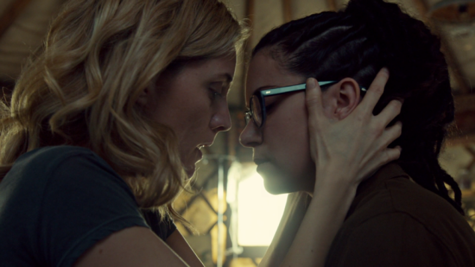 Delphine holds Cosima's head close to hers, looking intense.