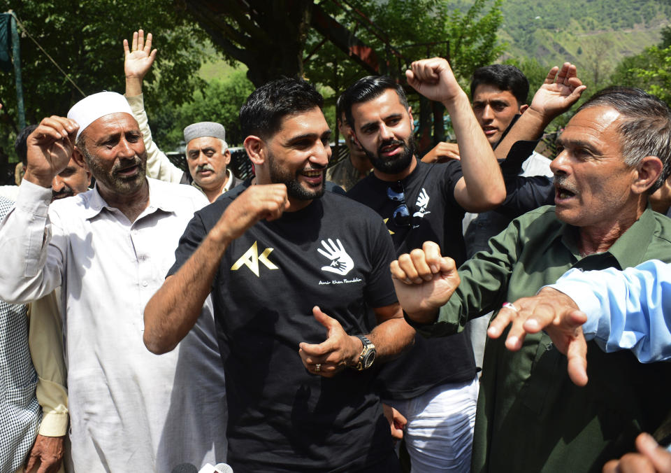 British boxer, promoter and philanthropist Amir Khan, center, meets Pakistani Kashmiris living at the Line of Control between Pakistan and Indian Kashmir, at the border area of Chakoti, in Pakistani Kashmir, Tuesday, Aug. 27, 2019. Khan visited the Line of Control on Tuesday to meet the families affected by India's ceasefire violations and to express solidarity with the people in Indian Kashmir. (AP Photo/M.D. Mughal)