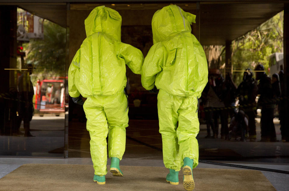 Police officers wearing chemical protection suits attend a simulation of a chemical attack, in preparation for any extreme situations during the upcoming World Cup, in Sao Paulo, Brazil, Tuesday, March 25, 2014. (AP Photo/Andre Penner)