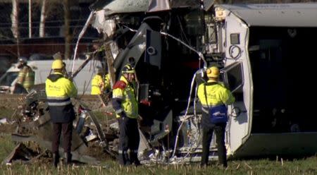 Emergency workers are seen next to a derailed Dutch passenger train in Dalfsen, Netherlands, in this still image from a video released February 23, 2016. REUTERS/NOS via Reuters TV