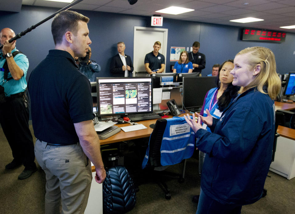 Acting Homeland Security Secretary Kevin McAleenan, left, speaks with FEMA personnel, as he gets information about a storm system, in a visit to the National Response Coordination Center at FEMA headquarters in Washington, Sunday, July 14, 2019. (AP Photo/Jose Luis Magana)