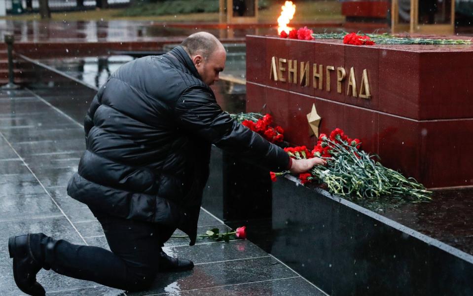 A man laying flowers at the Leningrad Hero City memorial by the Kremlin Wall in memory of the St Petersburg Metro explosion victims - Credit: TASS/Barcroft Images