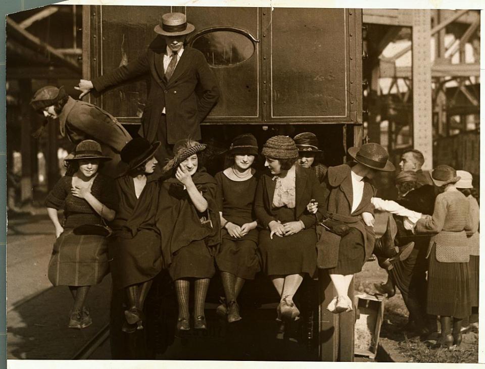 <p>A group of Manhattan department store employees hitch a ride on the back of the company's delivery truck.</p>