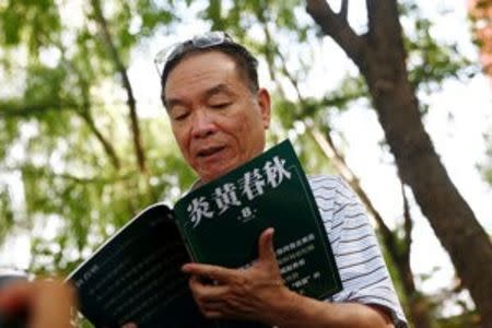 Wang Yanjun, former vice editor-in-chief of the liberal magazine Yanhuang Chunqiu, also known as China Through the Ages, holds an issue of the magazine as he speaks to the media outside the Chaoyang District Court in Beijing, China, August 16, 2016. REUTERS/Thomas Peter