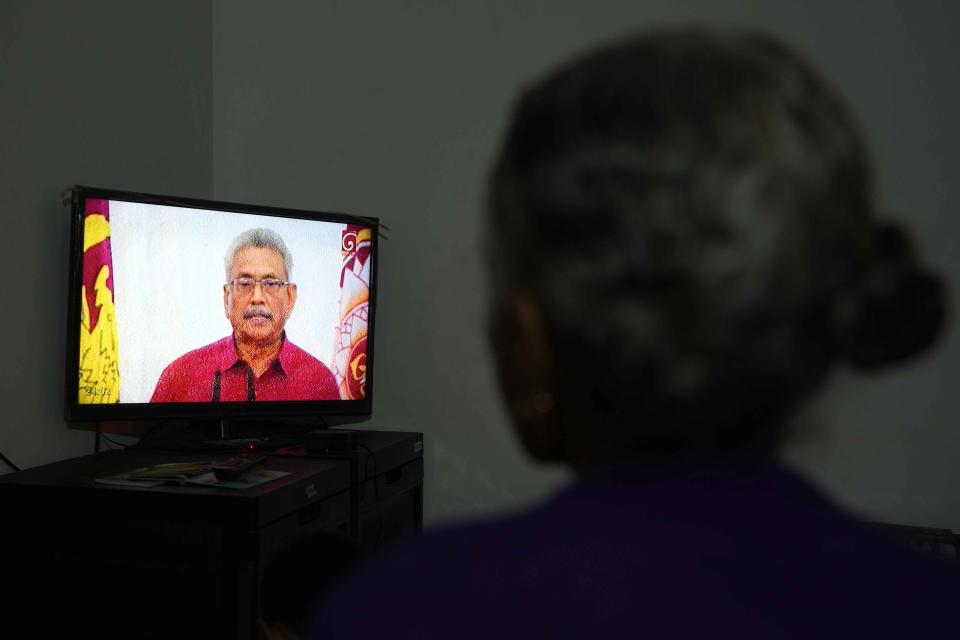 A Sri Lankan woman watches a telecast speech of President Gotabaya Rajapaksa at her house in Colombo, Sri Lanka, Wednesday, May 11, 2022. Anti-government protesters have been demanding the resignations of President Gotabaya Rajapaksa and his brother, who stepped down as prime minister this week, over a debt crisis that has nearly bankrupted Sri Lanka and left its people facing severe shortages of fuel, food and other essentials. (AP Photo/Eranga Jayawardena)