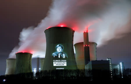 Greenpeace activists project images of German Chancellor Angela Merkel (top), German Economy minister Peter Altmaier, SPD chairwoman Andrea Nahles and German Transport minister Andreas Scheuer (L-R) with a slogan onto a cooling tower of the brown coal power plant of RWE, one of Europe's biggest utilities in Neurath, north-west of Cologne, Germany, December 14, 2018. REUTERS/Wolfgang Rattay