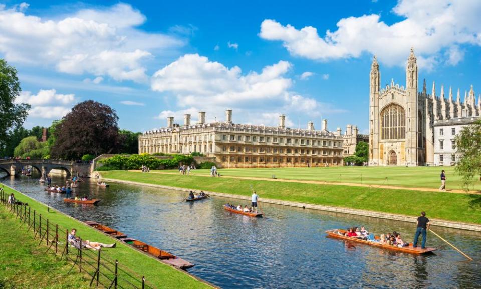 Punts with tourists along the river, in front of a college in Cambridge