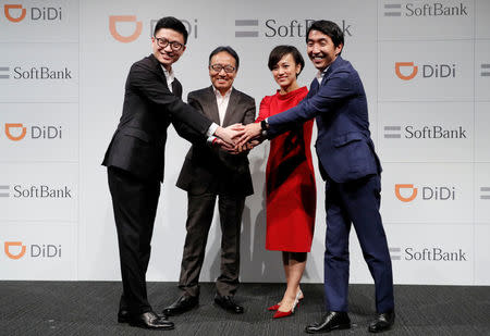 Vice President of Didi Chuxing Stephen Zhu, SoftBank Corp's CEO Ken Miyauchi, President of Didi Chuxing Jean Liu and SoftBank Corp' executive Keigo Sugano shake hands after a news conference about their Japanese taxi-hailing joint venture in Tokyo, Japan, July 19, 2018. REUTERS/Kim Kyung-Hoon