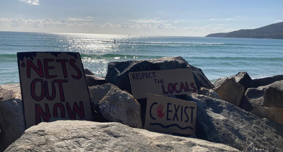 Protesters displayed signs at Noosa Heads, calling for shark nets to be removed. Source: Supplied