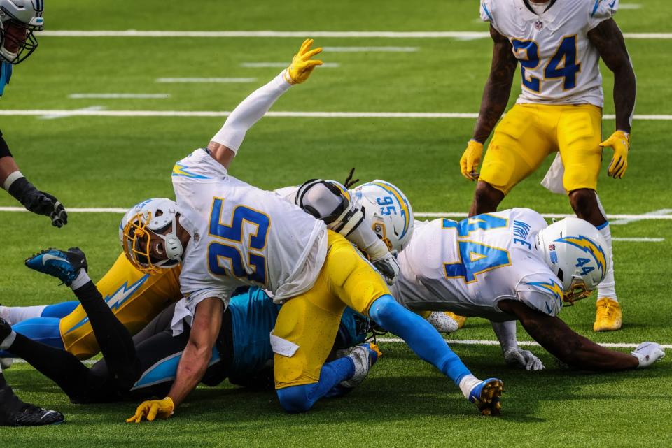 The Chargers' Chris Harris (25) writhes in pain after injuring his leg while tackling Panthers running back Mike Davis.