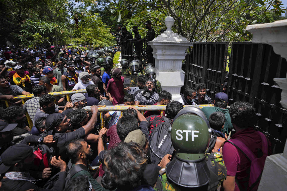 Protesters use an iron barricade to break the gate as they storm the compound of Sri Lankan Prime Minister Ranil Wickremesinghe's office, demanding he resign after president Gotabaya Rajapaksa fled the country amid economic crisis in Colombo, Sri Lanka, Wednesday, July 13, 2022. Sri Lanka’s president fled the country without stepping down Wednesday, plunging a country already reeling from economic chaos into more political turmoil. Protesters demanding a change in leadership then trained their ire on the prime minister and stormed his office. (AP Photo/Eranga Jayawardena)