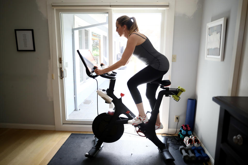 SAN ANSELMO, CALIFORNIA - APRIL 07:  Jen Van Santvoord rides her Peloton exercise bike at her home on April 07, 2020 in San Anselmo, California.  More people are turning to Peloton due shelter-in-place orders because of the coronavirus (COVID-19). The Peloton stock has continued to rise over recent weeks even as most of the stock market has plummeted. Peloton announced yesterday that they will temporarily pause all live classes until the end of April because an employee tested positive for COVID-19.  (Photo by Ezra Shaw/Getty Images)