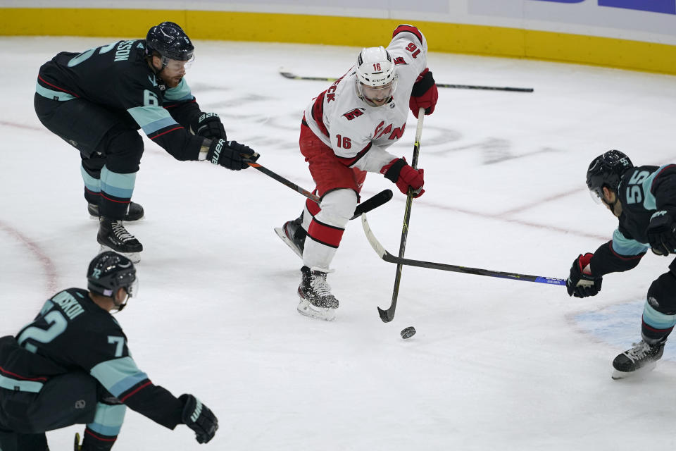 Carolina Hurricanes center Vincent Trocheck (16) shoots against Seattle Kraken defensemen Adam Larsson, left, and Jeremy Lauzon, right, during the second period of an NHL hockey game Wednesday, Nov. 24, 2021, in Seattle. (AP Photo/Ted S. Warren)