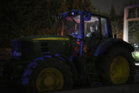 A farmer spends the night in his tractor at a highway barricade in Aix-en-Provence, southern France, Tuesday, Jan. 30, 2024. France's protesting farmers encircled Paris with traffic-snarling barricades Monday, using hundreds of lumbering tractors and mounds of hay bales to block highways leading to France's capital to pressure the government over the future of their industry. (AP Photo/Daniel Cole)