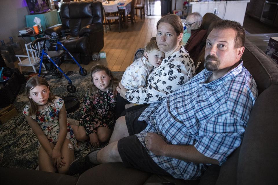 George Adair and his wife, Catherine, daughters Sarah Pittman (left) and Anne Marie, son George Jr., and father Francis, sit inside their Buckeye home Feb. 14, 2021. George's mother, Phyllis, was a flight attendant for American Airlines and died Feb. 2 from COVID-19.